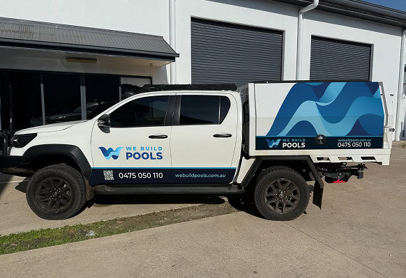 Growthify pool construction truck parked outside a building.