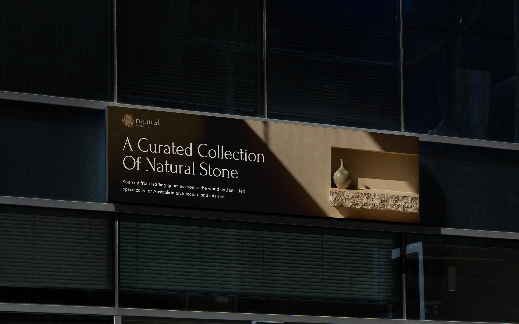 Natural Stone curated collection sign on modern building exterior.